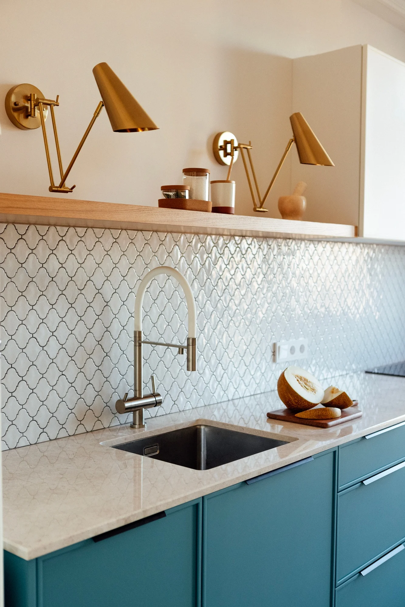 A modern kitchen with a blue set and a marble countertop